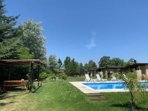 a backyard with a swimming pool and a picnic table at Complejo La Querencia de Colón in Colón