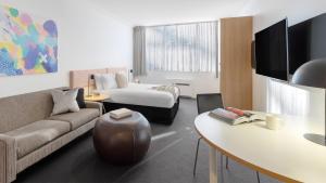 ein Hotelzimmer mit einem Bett und einem Sofa in der Unterkunft Oaks Perth Hotel in Perth