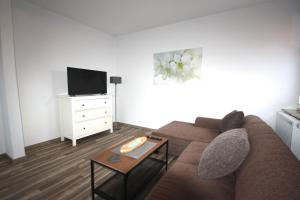 a living room with a couch and a tv at Möwennest III in Emden