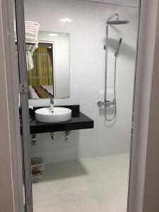 een badkamer met een wastafel, een spiegel en een douche bij Khách Sạn Sông Hiến in Cao Bằng