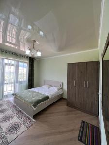 a bedroom with a bed and a large window at Гостевой дом RAZAM in Bosteri