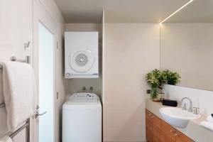 Un baño con lavadora y lavabo. en The Old Woolstore Apartment Hotel, en Hobart