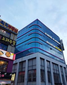 un edificio de cristal alto con un cartel. en Busan Platinum Hotel Nampo, en Busan