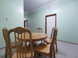 a dining room with a wooden table and chairs at DIY Palm Court 3BR Apartment, 7 Guests in Kuantan