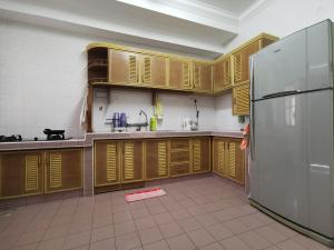 a kitchen with wooden cabinets and a stainless steel refrigerator at DIY Palm Court 3BR Apartment, 7 Guests in Kuantan