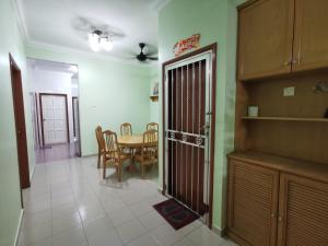 a kitchen and dining room with a table and a door at DIY Palm Court 3BR Apartment, 7 Guests in Kuantan