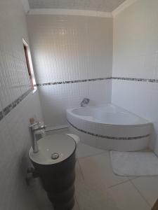 LINGE'S LODGE EXTENSION في Lusikisiki: حمام مع حوض ومرحاض ومغسلة