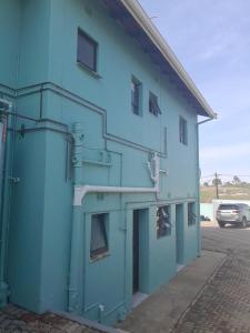 niebieski budynek z drzwiami i oknami w obiekcie LINGE'S LODGE EXTENSION w mieście Lusikisiki