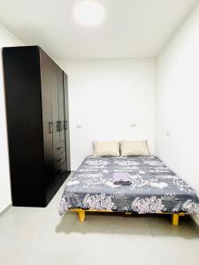 a bedroom with a bed and a black cabinet at КВАРТИРА С ДВОРИКОМ! in Haifa