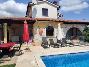 a villa with a swimming pool in front of a house at Rustic house with private Pool in Šišan