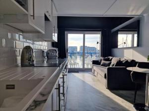 a kitchen and living room with a couch and a table at Sea Breeze in Brighton Marina with Free Parking in Brighton & Hove