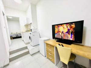 a living room with a flat screen tv on the wall at КВАРТИРА С ДВОРИКОМ! in Haifa