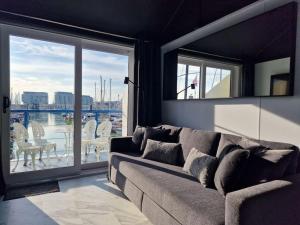 a living room with a couch and a large window at Sea Breeze in Brighton Marina with Free Parking in Brighton & Hove