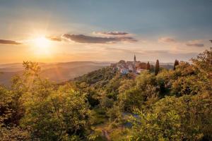 a castle on top of a hill with the sun setting at Casa Stella in Draguć