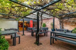 un patio con mesas y bancos en un edificio en The Old Woolstore Apartment Hotel, en Hobart