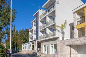 un edificio de apartamentos con balcones en una calle en Guest House Aria, en Herceg-Novi