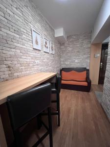 ein Zimmer mit einem Tisch, Stühlen und einer Ziegelwand in der Unterkunft MNM Mitropolie in Iaşi