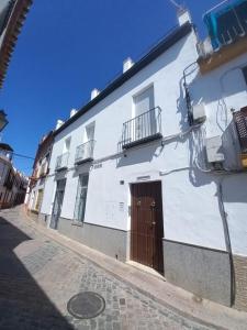 a white building with a brown door on a street at Casa Puerta de Almodovar in Córdoba