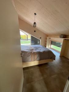 a bed in a small room with a window at Magnifique villa nature le Bois d'Aura in Luisans