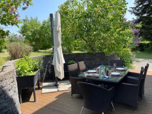 una mesa y sillas en un patio con sombrilla en Appartement de standing à Vallorbe, en Vallorbe