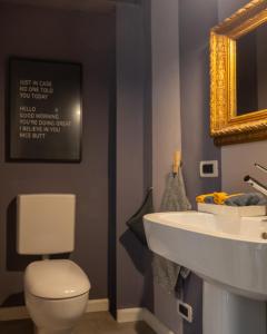 a bathroom with a white toilet and a sink at Esclusiva Casa indipendente in Centro in Udine
