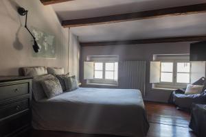 1 dormitorio con 1 cama, 1 sofá y 2 ventanas en Esclusiva Casa indipendente in Centro en Udine
