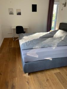 Ferienwohnung im Mittelpunkt في Nortorf: غرفة نوم مع سرير ومكتب مع كرسي