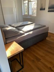 Ferienwohnung im Mittelpunkt في Nortorf: سرير في غرفة مع أرضية خشبية