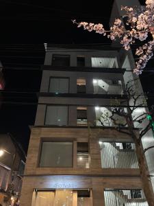 ein Gebäude in der Nacht mit einem Baum davor in der Unterkunft ABiz hotel in Kyoto
