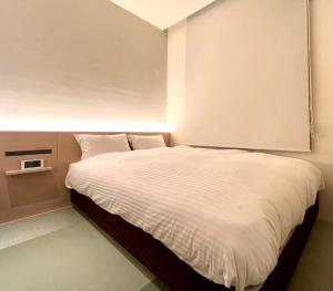 ABiz hotel في كيوتو: غرفة نوم بسرير كبير مع شراشف بيضاء