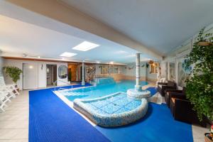 a large swimming pool with a blue floor in a room at Pension Kofler in Vollan
