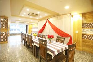 een eetkamer met een tafel met stoelen en bloemen bij OYO Hotel Shanti Palace in Sikandra