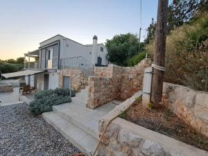 a home with a stone retaining wall and a house at Villa Stjepan in Zavala