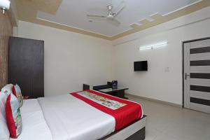 a bedroom with a bed with a red blanket at OYO Hotel Shanti Palace in Sikandra