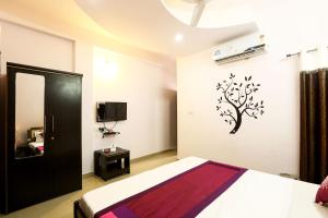 a bedroom with a bed and a tree stencil on the wall at OYO Hotel Plaza Inn in Bhopal
