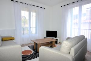 a white living room with a couch and a table at Tres Vents del Roser - grand appartement in Prats-de-Mollo-la-Preste