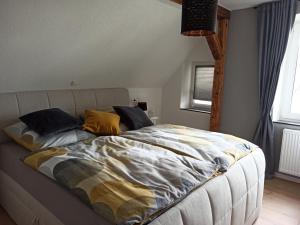 a bedroom with a large bed with yellow pillows at Ferienhaus Dinger in Rüssingen