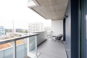 einen Balkon eines Gebäudes mit einem Stuhl darauf in der Unterkunft Lovely Apartment in Marina Tower - 10min to City Center in Wien