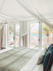 1 dormitorio con 1 cama y vistas al océano en Hôtel 20 Degrés Sud - Relais & Châteaux en Grand Baie