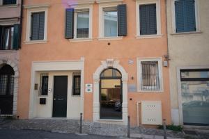 un edificio naranja con una puerta y ventanas negras en Calcirelli Suites en Verona