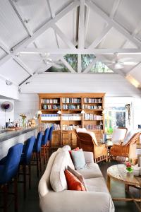 a living room with a lot of furniture and bookshelves at Hôtel 20 Degrés Sud - Relais & Châteaux in Grand Baie