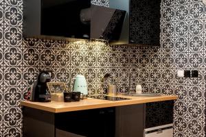 una cocina con papel pintado en blanco y negro y una encimera en * Love Room jacuzzi *, en Aubie-et-Espessas