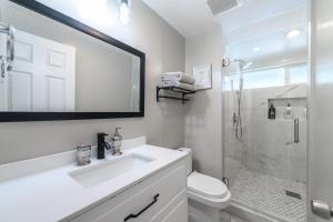 a white bathroom with a sink and a shower at Disneyland Dream Villa 5 BR 3 BA Arcade Games in Anaheim +43 photos
