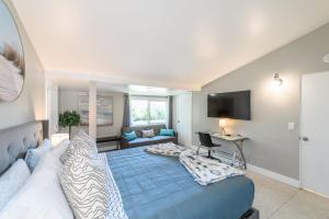 ein Schlafzimmer mit einem blauen Bett und einem Sofa in der Unterkunft Disneyland Dream Villa 5 Bedroom 3 Bath Theater Games Pool Table in Anaheim
