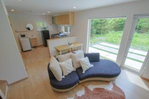a living room with a blue couch with pillows at Furano Hidden Hill【FHH】 in Kami-furano