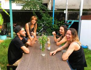 a group of people sitting around a wooden table at Bamboo Hostel in Thakhek
