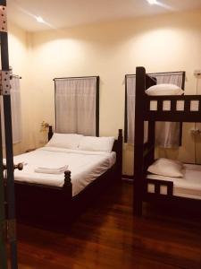 董里的住宿－Thunyaporn Hostel，铺有木地板的客房内配有两张双层床。