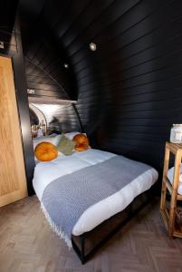 a bedroom with a bed in a black wall at North Coast 500 Pods in Achmelvich