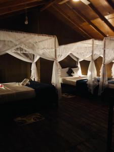 1 dormitorio con 2 camas con cortinas blancas en Galaxy View Homestay Sigiriya, en Sigiriya