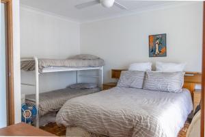 a bedroom with two bunk beds and a bed at Paradise on the Water in Sussex Inlet